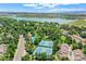 Aerial view showcases community pool, tennis courts, and lake with surrounding trees and houses at 2972 W Long Dr # C, Littleton, CO 80120