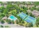 Aerial view of a tennis courts and pool area within a neighborhood with lush trees and parking at 2972 W Long Dr # C, Littleton, CO 80120
