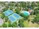 Aerial view of community tennis courts and pool area surrounded by lush trees and landscaping at 2972 W Long Dr # C, Littleton, CO 80120