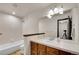 Bathroom featuring a large mirror over a wood vanity and a shower over tub at 2972 W Long Dr # C, Littleton, CO 80120
