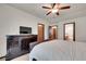 Spacious bedroom featuring dark wood furniture, ceiling fan, television, and multiple doors at 2972 W Long Dr # C, Littleton, CO 80120