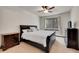 Well-lit bedroom with a black bed frame, side tables, dresser, ceiling fan, and a bright window at 2972 W Long Dr # C, Littleton, CO 80120