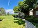 Beautiful exterior with a lush green lawn, mature trees and brick accents on a sunny day at 2972 W Long Dr # C, Littleton, CO 80120