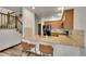 Open kitchen with granite countertops, bar seating, and wooden cabinets at 2972 W Long Dr # C, Littleton, CO 80120