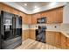 Bright kitchen with stainless steel appliances, wooden cabinets, granite counters, and tile backsplash at 2972 W Long Dr # C, Littleton, CO 80120