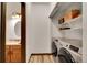 Convenient laundry room featuring washer and dryer, storage shelves, and a half bathroom at 2972 W Long Dr # C, Littleton, CO 80120