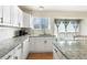 Eat-in kitchen with white cabinets and granite countertops at 5593 S Himalaya Way, Centennial, CO 80015