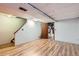 Unfinished basement area with wood-look flooring and access to the laundry area at 1200 S Monaco St Pkwy # 31, Denver, CO 80224