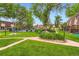 Green community space with lawn, trees, walkway and community pool behind a black fence at 1200 S Monaco St Pkwy # 31, Denver, CO 80224