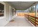 Covered back patio area with a stained wood railing overlooking the yard with a wood fence at 3222 S Fairfax St, Denver, CO 80222