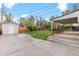 Spacious backyard with a shed, carport, and mature trees with a concrete patio at 3222 S Fairfax St, Denver, CO 80222