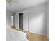Well-lit bedroom showcases an open closet with shelving, complemented by hardwood floors and neutral wall colors at 3222 S Fairfax St, Denver, CO 80222