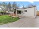Exterior view of the home featuring a covered patio, fenced yard, and manicured lawn at 3222 S Fairfax St, Denver, CO 80222