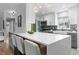 Modern kitchen featuring a large island with bar seating, white cabinetry, and stainless steel appliances at 3222 S Fairfax St, Denver, CO 80222