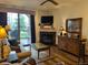 Cozy living room with fireplace, television, couch and a sliding glass door to balcony at 34 Highfield Trl # 212, Breckenridge, CO 80424