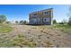 A sunny backyard with a large grass area surrounds the exterior of the two-story home at 16275 Electra St, Brighton, CO 80603