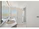 Bright bathroom featuring double sinks, a large mirror, and a separate shower room at 16275 Electra St, Brighton, CO 80603