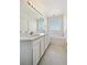 Bright bathroom featuring double sinks, vanity storage, tub, and a block window at 16275 Electra St, Brighton, CO 80603