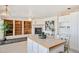 Bright and airy kitchen featuring an island, open to a dining area, a fireplace, and built-in bookshelves at 16275 Electra St, Brighton, CO 80603