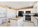 Charming kitchen with white cabinets, stainless steel appliances, and center island with breakfast bar seating at 16275 Electra St, Brighton, CO 80603