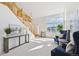 Spacious living room featuring an open staircase, ample natural light, and comfortable seating for relaxation at 16275 Electra St, Brighton, CO 80603