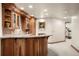 Basement bar features wood cabinetry, granite countertops, a tile backsplash, and wine storage at 4 Redhawk Run, Englewood, CO 80113