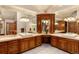 Luxurious bathroom featuring and sink vanities, ample cabinetry and many lights and mirrors at 4 Redhawk Run, Englewood, CO 80113
