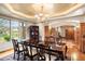 Elegant dining room with a large wooden table, chandelier, and large windows offering natural light at 4 Redhawk Run, Englewood, CO 80113