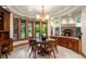 Sunlit dining room with round table, large windows, and backyard views at 4 Redhawk Run, Englewood, CO 80113