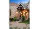 Detailed stone entrance with brick columns, decorative lighting, and well-manicured landscaping at 4 Redhawk Run, Englewood, CO 80113
