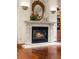 Close-up of an elegant fireplace with stone surround, decorative mirror, and sconce lighting at 4 Redhawk Run, Englewood, CO 80113