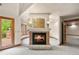 Statement fireplace adjoined to other rooms, surrounded by windows and a nearby door to a balcony at 4 Redhawk Run, Englewood, CO 80113