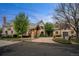 Stunning stone home with a circular driveway, mature landscaping, and welcoming curb appeal at 4 Redhawk Run, Englewood, CO 80113