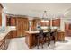 Kitchen with island seating, stainless steel appliances, and wood cabinets at 4 Redhawk Run, Englewood, CO 80113