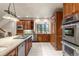 Kitchen with stainless steel appliances, wood cabinets, tiled floor, and island at 4 Redhawk Run, Englewood, CO 80113