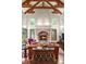 Open-concept living room with a large brick fireplace, vaulted ceiling, and hardwood floors with exposed wood beams at 4 Redhawk Run, Englewood, CO 80113