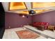 Home theater room in basement with projector screen, tiered seating, a sofa, and area rug at 4 Redhawk Run, Englewood, CO 80113