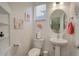 Charming powder room features a pedestal sink, oval mirror, and decorative wall art at 4754 N Joplin St, Denver, CO 80239