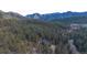 Aerial view of a secluded home nestled among lush green trees and mountains at 1406 Pika Rd, Boulder, CO 80302