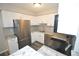 Updated kitchen features stainless steel appliances, granite counters, gray subway tile backsplash, and white cabinetry at 11937 E Harvard Ave # 101, Aurora, CO 80014