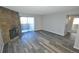 Living room featuring wood-look floors, a stone fireplace and access to the outdoor living space at 11937 E Harvard Ave # 101, Aurora, CO 80014