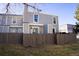 Townhome's exterior shows a private fenced yard and a gray facade against a clear blue sky at 19803 Victorian Way, Parker, CO 80138