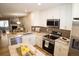 Open-concept kitchen with stainless steel appliances, granite countertops, and a view of the living area at 19803 Victorian Way, Parker, CO 80138