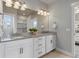 Bathroom with granite countertops, double sinks, and a large framed mirror at 5399 Valentia St, Denver, CO 80238
