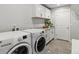 Well-lit laundry room with white cabinetry, granite countertops, and modern washer and dryer at 5399 Valentia St, Denver, CO 80238