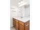 Bathroom featuring a wooden vanity, large mirror, shelving, and modern lighting at 23293 E Jamison Dr, Aurora, CO 80016