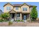 Charming tan townhouse with stone accents, well-kept landscaping and a cozy, covered front porch at 23293 E Jamison Dr, Aurora, CO 80016
