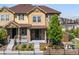 Inviting tan townhouse with stone accents, complemented by a covered front porch and attractive landscaping at 23293 E Jamison Dr, Aurora, CO 80016