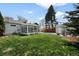 The backyard has a beautiful sunroom, green lawn, and detached garage at 1757 S Elm St, Denver, CO 80222