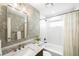 Stylish bathroom featuring floral wallpaper, marble countertop, and a bathtub with a shower at 1757 S Elm St, Denver, CO 80222